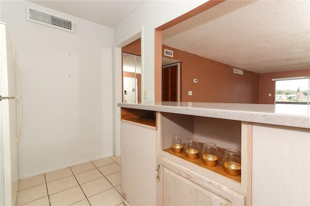 626 Orange Dr Unit 242, Altamonte Springs, FL 32701 - interior space with light tile patterned flooring, a textured ceiling, white fridge, and light brown cabinets