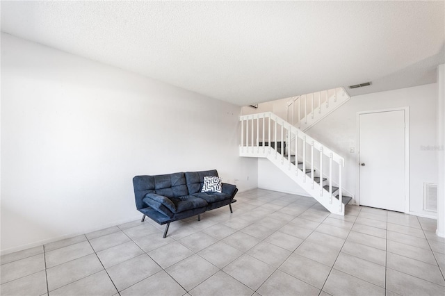 living area with a textured ceiling and light tile patterned floors