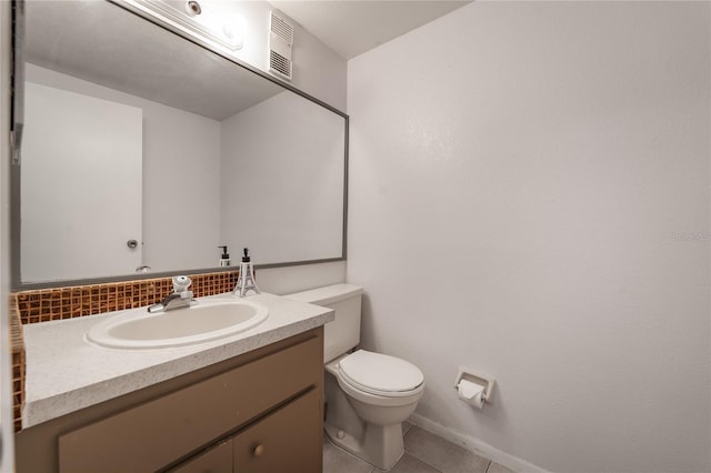 bathroom with tasteful backsplash, vanity, tile patterned floors, and toilet