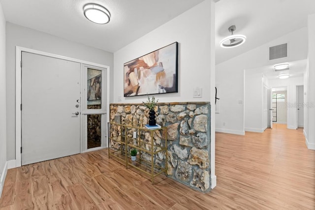 entrance foyer featuring light hardwood / wood-style floors and lofted ceiling