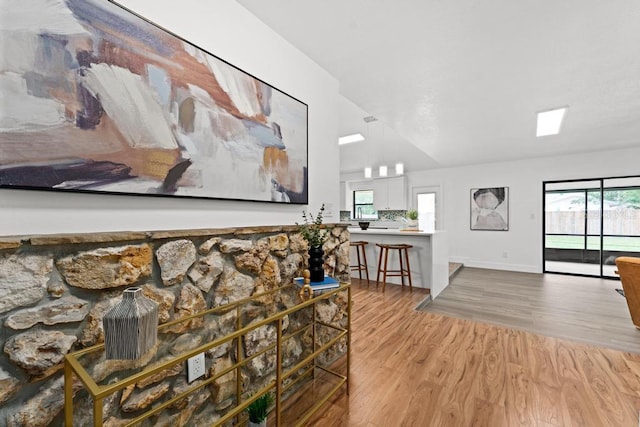 living room featuring vaulted ceiling and light hardwood / wood-style floors