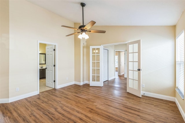 empty room featuring wood-type flooring, french doors, ceiling fan, and vaulted ceiling