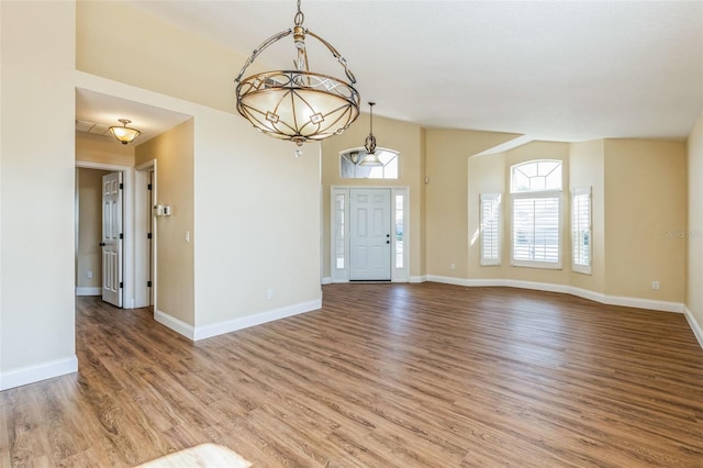 foyer entrance featuring wood-type flooring and vaulted ceiling