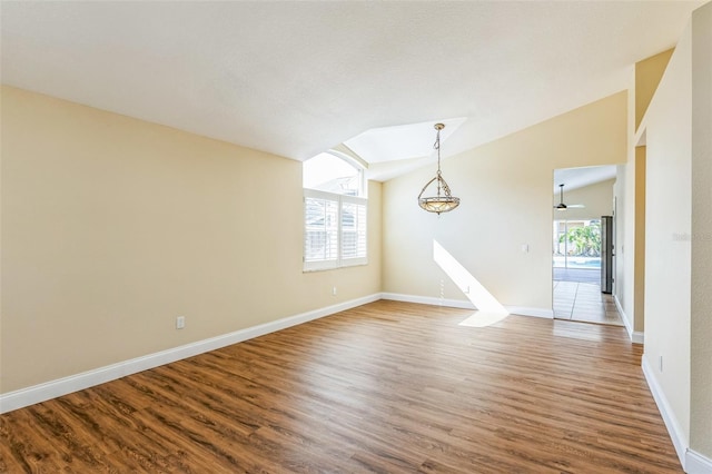 unfurnished room with lofted ceiling, hardwood / wood-style floors, and plenty of natural light