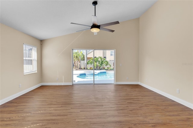 unfurnished room featuring hardwood / wood-style flooring, lofted ceiling, and ceiling fan