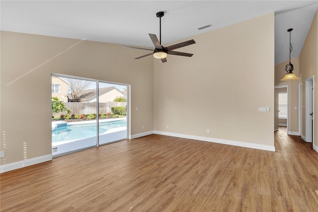 empty room featuring high vaulted ceiling, light hardwood / wood-style floors, and ceiling fan