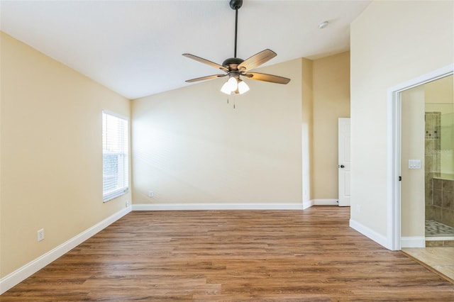 spare room with hardwood / wood-style floors, vaulted ceiling, and ceiling fan