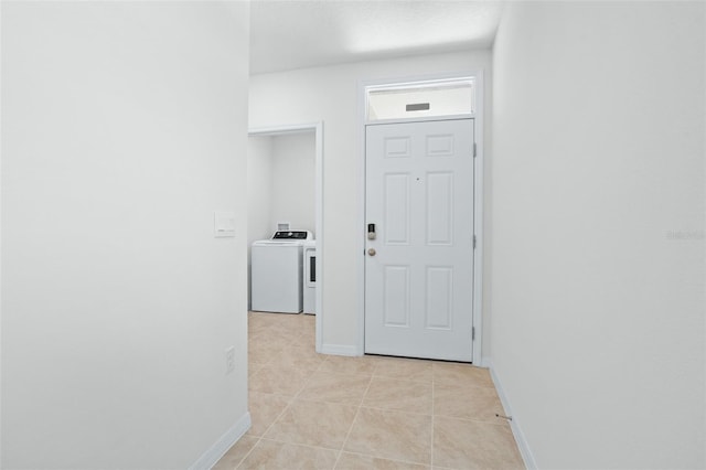 hall featuring washer / dryer and light tile patterned floors