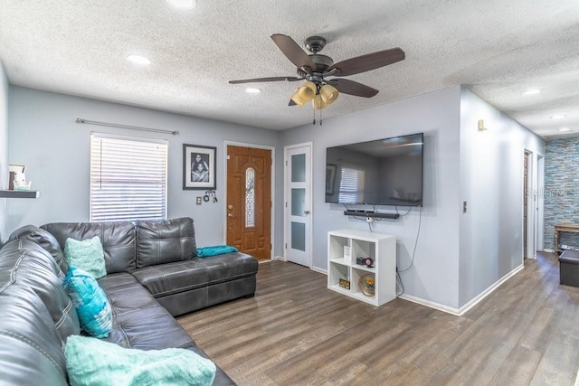 living room featuring ceiling fan, hardwood / wood-style floors, and a textured ceiling