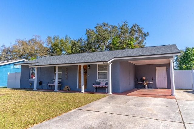 ranch-style house featuring a carport, a porch, and a front yard