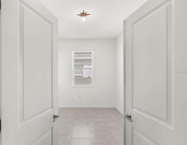 spare room with light tile patterned floors and a textured ceiling