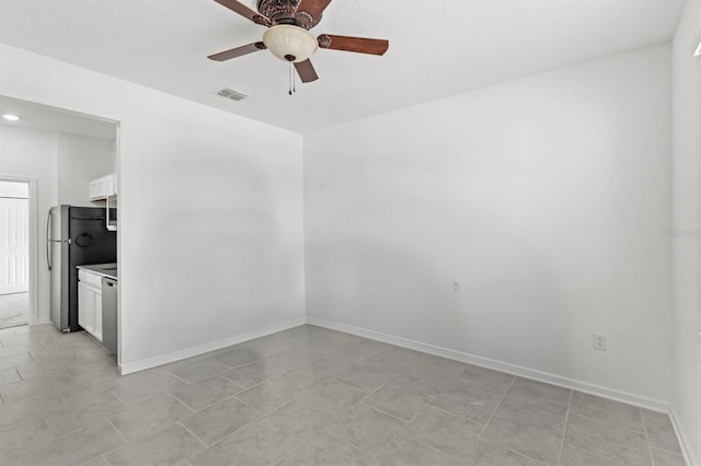 tiled empty room featuring ceiling fan