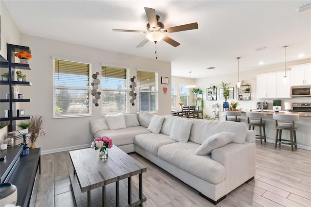 living room featuring light hardwood / wood-style flooring and ceiling fan