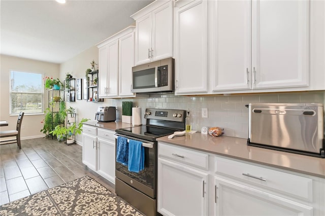 kitchen with white cabinetry, stainless steel appliances, and backsplash