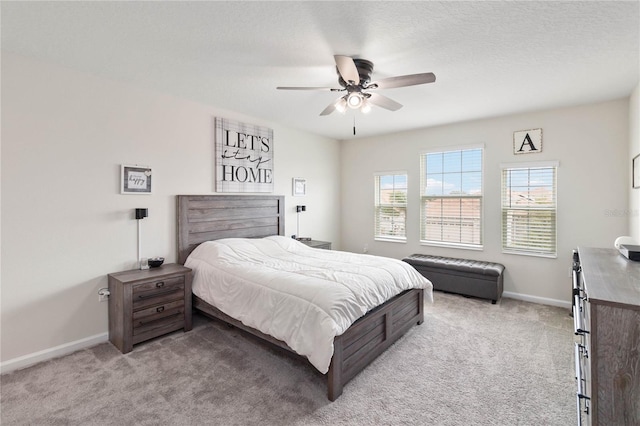 carpeted bedroom with ceiling fan and a textured ceiling