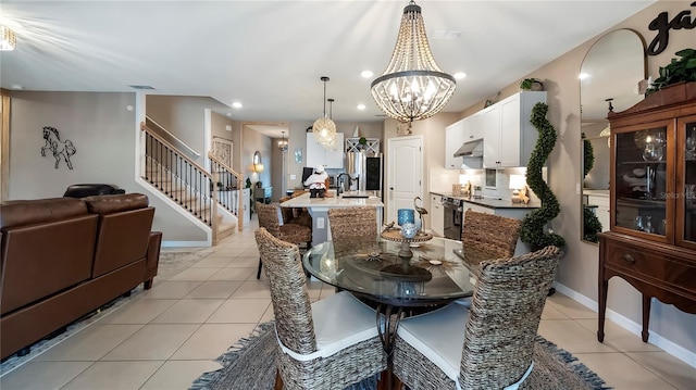 dining area with light tile patterned floors, visible vents, an inviting chandelier, baseboards, and stairs