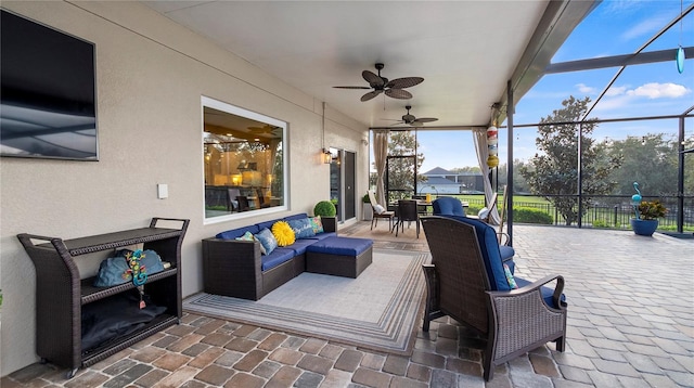 view of patio featuring glass enclosure, outdoor dining area, outdoor lounge area, fence, and a ceiling fan