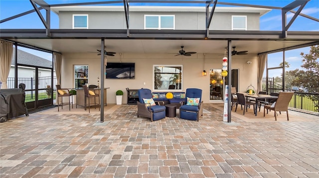 view of patio / terrace with an outdoor living space, a lanai, and a ceiling fan