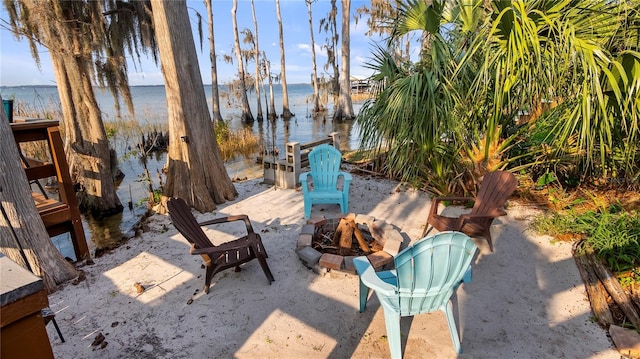 view of patio featuring an outdoor fire pit and a water view