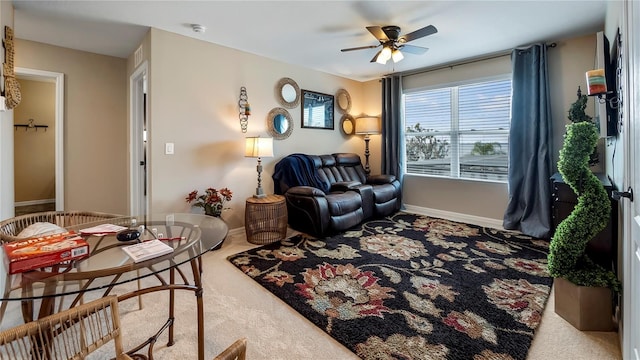 carpeted living room featuring ceiling fan and baseboards