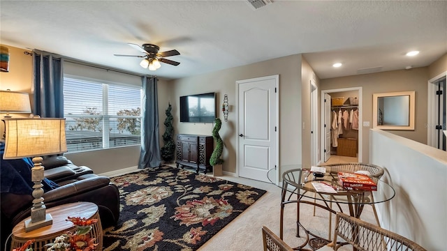 living area featuring light carpet, visible vents, baseboards, ceiling fan, and recessed lighting