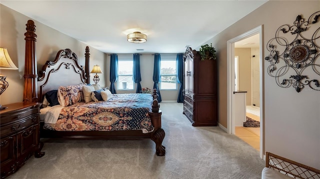 bedroom featuring light carpet, baseboards, and ensuite bathroom