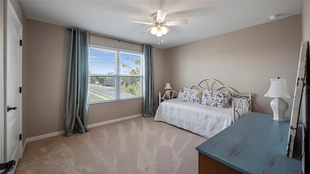 bedroom featuring baseboards, ceiling fan, and light colored carpet