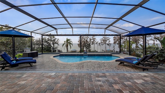 outdoor pool with glass enclosure and a patio