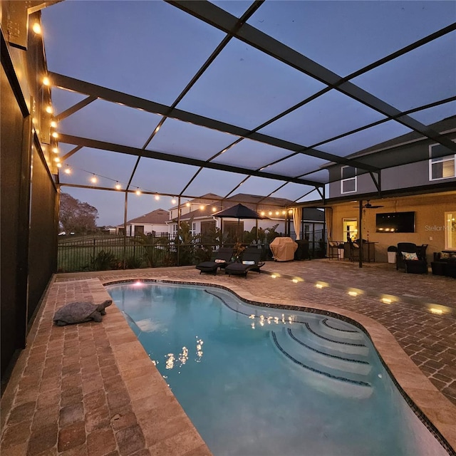 view of swimming pool with glass enclosure, a patio area, fence, and a fenced in pool