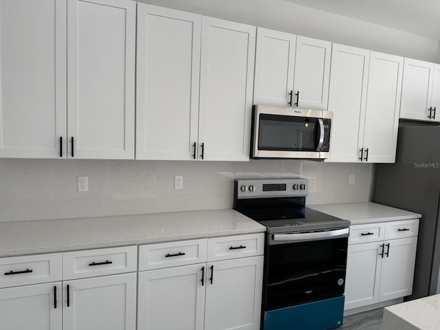 kitchen with white cabinetry, tasteful backsplash, and stainless steel appliances