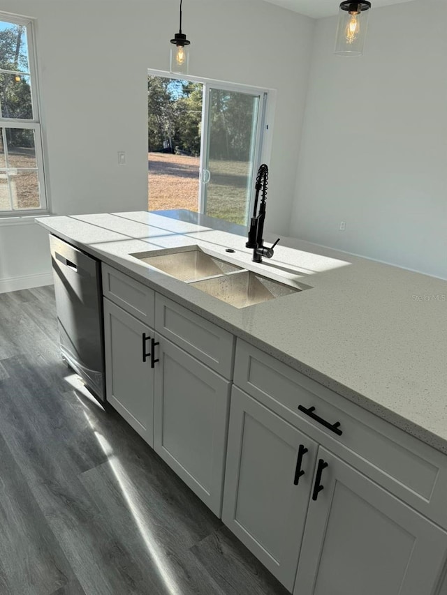 kitchen with sink, light stone counters, white cabinetry, hanging light fixtures, and stainless steel dishwasher