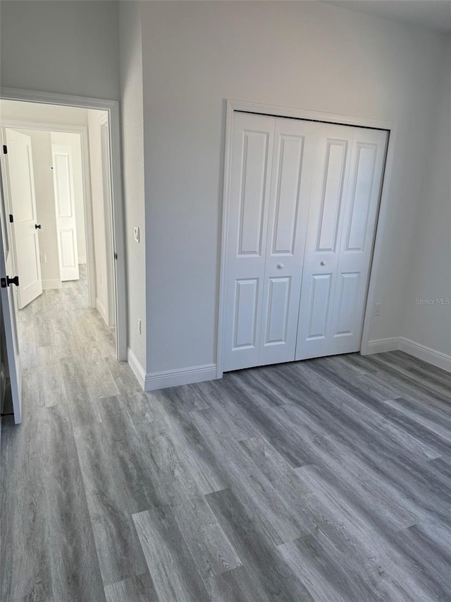 unfurnished bedroom with dark hardwood / wood-style flooring and a closet