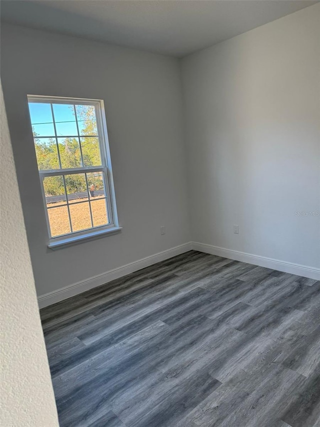 empty room with dark hardwood / wood-style flooring