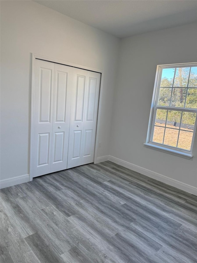 unfurnished bedroom featuring dark hardwood / wood-style floors and a closet