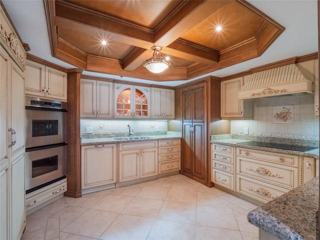 kitchen with stainless steel double oven, premium range hood, sink, black electric stovetop, and decorative backsplash