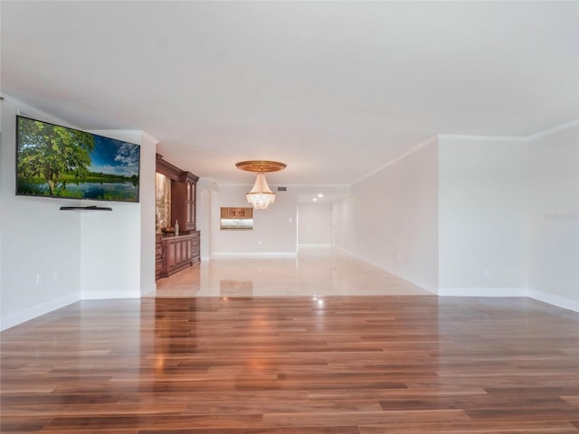 unfurnished living room with crown molding and wood-type flooring