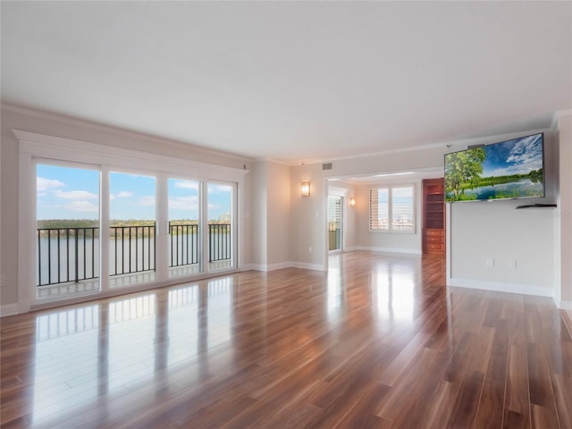 unfurnished living room featuring a water view, hardwood / wood-style flooring, and crown molding