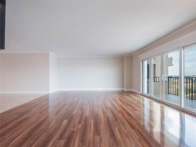 unfurnished living room featuring crown molding and dark hardwood / wood-style floors