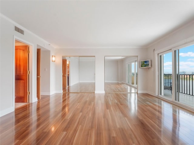 unfurnished room with crown molding and light hardwood / wood-style flooring