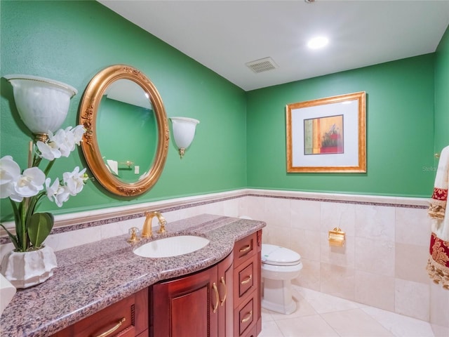 bathroom with tile walls, tile patterned flooring, vanity, and toilet