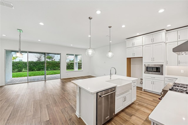 kitchen with decorative light fixtures, stainless steel appliances, visible vents, light countertops, and white cabinetry