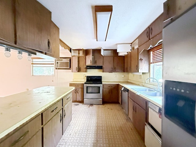 kitchen with stainless steel appliances, a healthy amount of sunlight, sink, and a wall mounted air conditioner