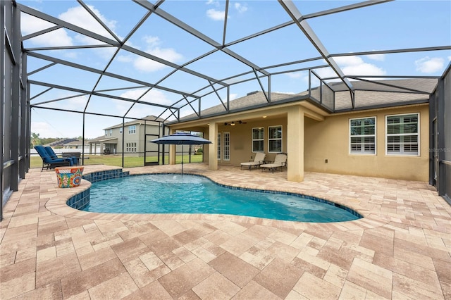 outdoor pool featuring a patio area, a lanai, and a ceiling fan