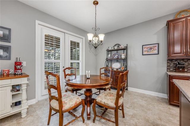 dining area featuring a notable chandelier and baseboards