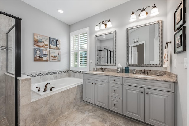 bathroom featuring a garden tub, double vanity, a sink, and a shower stall