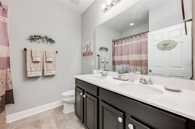 bathroom featuring baseboards, a sink, toilet, and double vanity