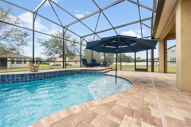 outdoor pool featuring glass enclosure and a patio