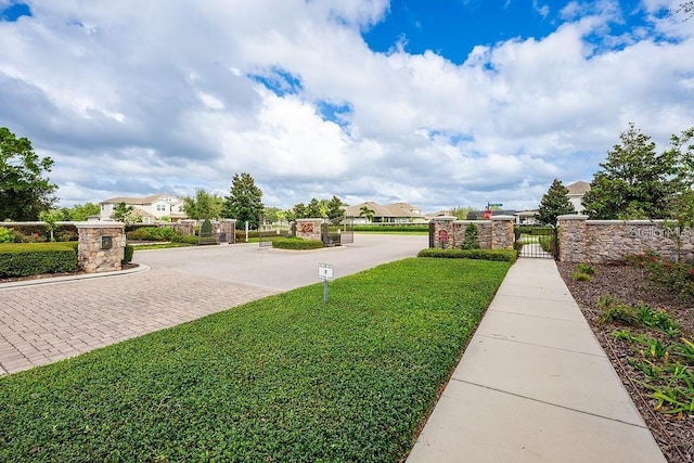 view of yard featuring a residential view, fence, and a gate