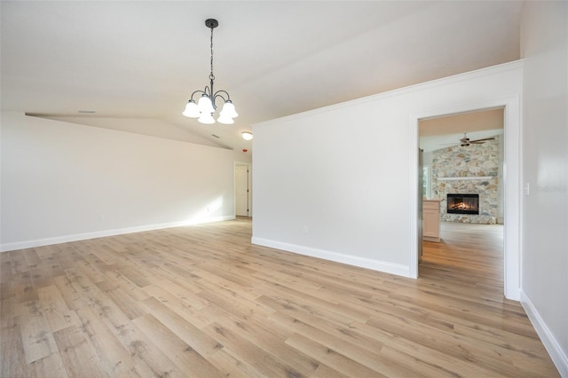 1001 Glencove Ave NW, Palm Bay, FL 32907 - spare room with a fireplace, vaulted ceiling, light wood-type flooring, and baseboards