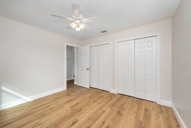 1001 Glencove Ave NW, Palm Bay, FL 32907 - unfurnished bedroom with light wood finished floors, baseboards, visible vents, a ceiling fan, and two closets